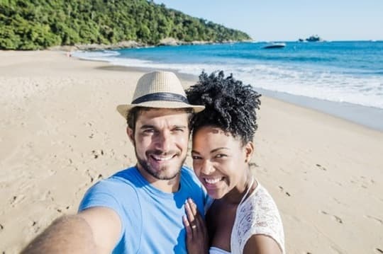 Two people on a beach on a bright day